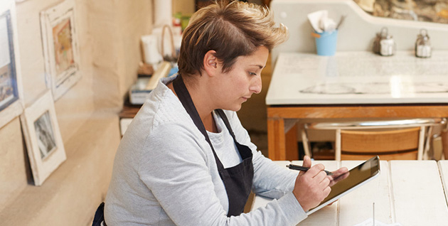 woman working on tablet  at her shop